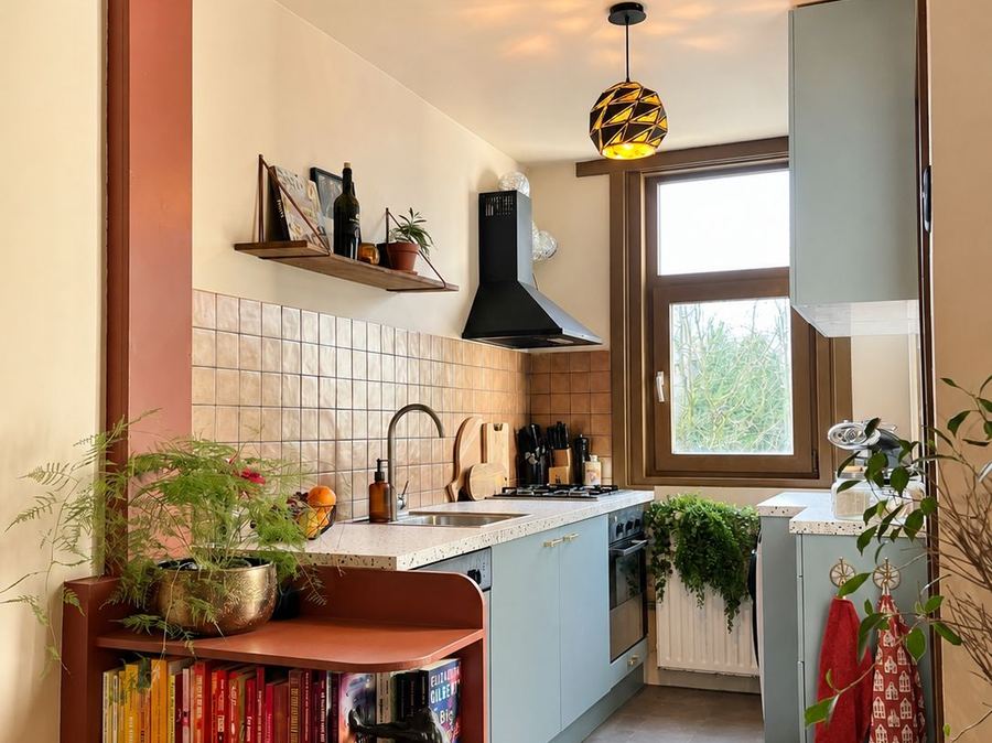 Saliegroene keuken met tegelwand en messing hanglamp